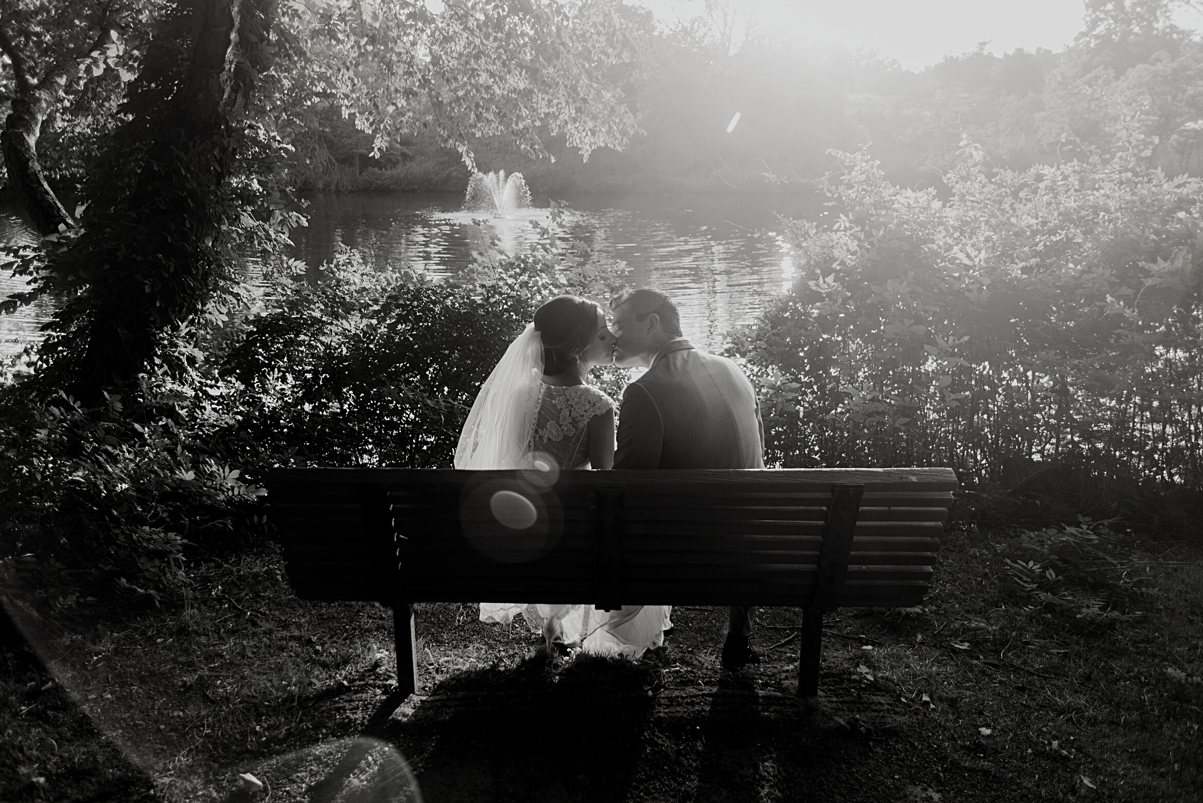 Newlyweds Kissing on a Bench Outdoors